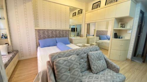a large bedroom with a large bed and a couch at VidaView Apartemen Ashton 10F By Millpro in Pampang
