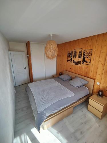 a bedroom with a large bed with a wooden wall at Maison a salers in Salers