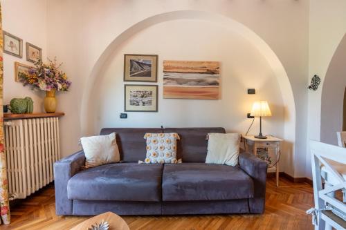 a living room with a blue couch and an archway at Villa Paradiso Apartment in Sirmione