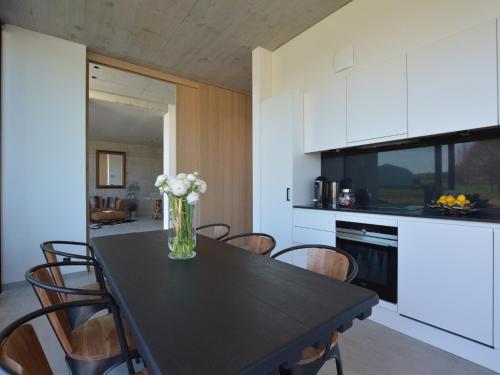 a kitchen with a table with a vase of flowers on it at Cozy Villa in Dalhem Ardennes with Private Garden in Dalhem