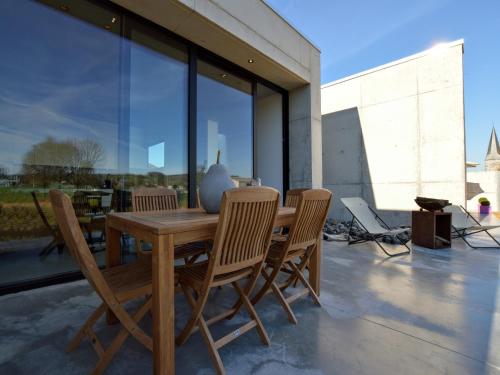 a wooden table and chairs on a patio at Cozy Villa in Dalhem Ardennes with Private Garden in Dalhem
