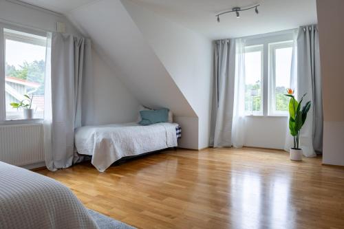 a white room with a bed and two windows at Apartment Near Sea and Nature, Free Parking & Cleaning in Gothenburg
