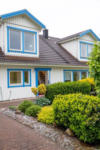 a house with blue windows and bushes in front of it at Apartment Near Sea and Nature, Free Parking & Cleaning in Gothenburg