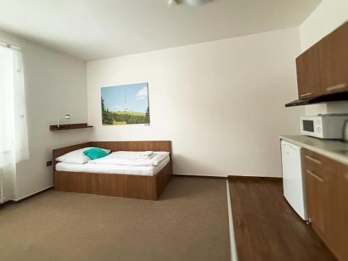 a small room with a bed in a kitchen at Hotel Pod Radnicí in Šumperk
