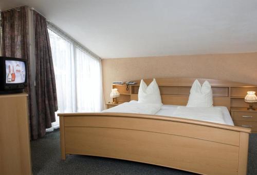 a hotel room with a large bed with white pillows at Götznerhof - Self-Check-in in Innsbruck