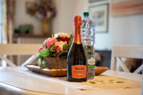 a bottle of wine sitting on a table next to a bottle of alcohol at Villa Paradiso Apartment in Sirmione