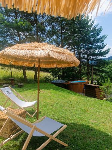 a straw umbrella and a chair under a straw at Domek Sielski Zakątek Pieniny in Szczawnica