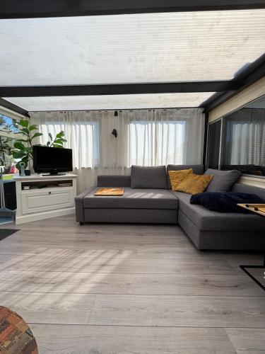 a living room with a couch and a tv at Zen House in Westergeest
