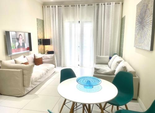 a living room with a couch and a table and chairs at Blue Lagoon seafront apartment in Flic-en-Flac