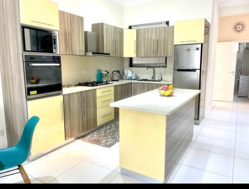 a kitchen with a white counter in the middle at Blue Lagoon seafront apartment in Flic-en-Flac