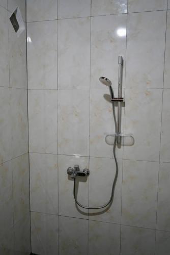 a shower with a shower head in a bathroom at Green Travelodge Bukit Lawang in Bukit Lawang