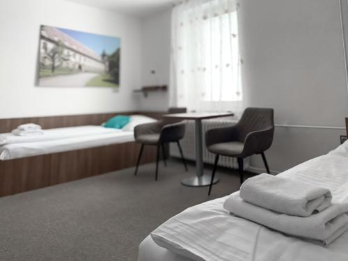 a hospital room with a bed and a table and chairs at Hotel Pod Radnicí in Šumperk