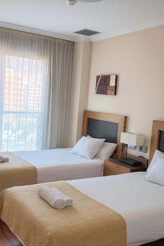 a hotel room with two beds and a window at vacation720 in Benalmádena