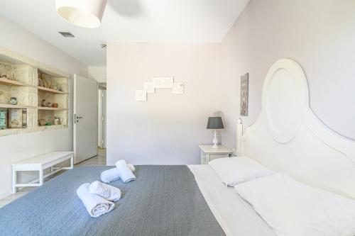 Un dormitorio blanco con dos toallas en una cama. en Delightful Seaside Villa, en Gouves