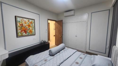 a bedroom with a bed and a painting on the wall at Homie's The Glory Apartment in Thu Dau Mot