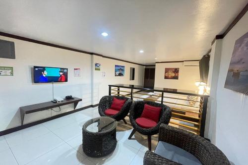 a living room with chairs and a tv and a table at Angeles Palace Hotel in Angeles