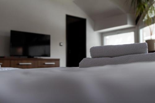 a bedroom with a white bed with a flat screen tv at Hotel Pod Radnicí in Šumperk