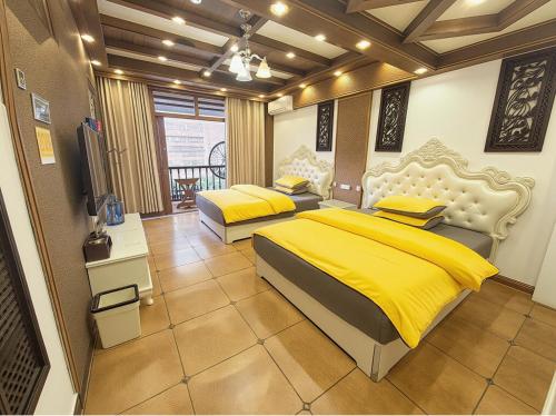 a bedroom with two beds with yellow sheets at Fenghuang Xiangyun Pavilion Boutique Riverside B&B in Fenghuang
