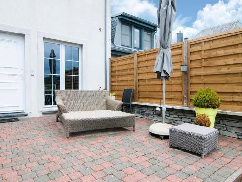 a patio with two chairs and an umbrella at Great holiday home in Bastogne with sauna in Le Parque