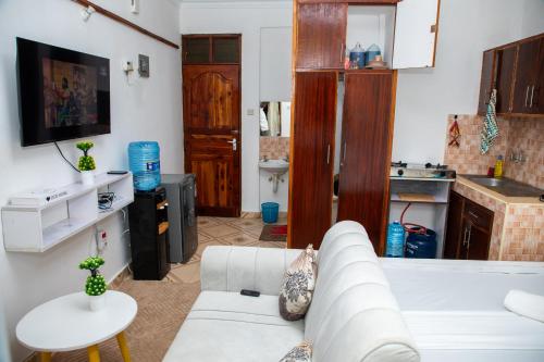 a living room with a white couch and a kitchen at Yunke Homes Comfortable Studio in Bamburi in Mombasa