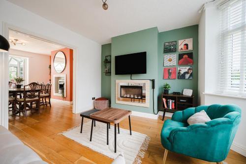 a living room with a blue couch and a tv at Heaton House - parkside charm and city comfort in Manchester
