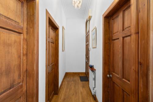 a hallway with wooden doors and wooden floors at Beach Walk Apartment in Broughty Ferry