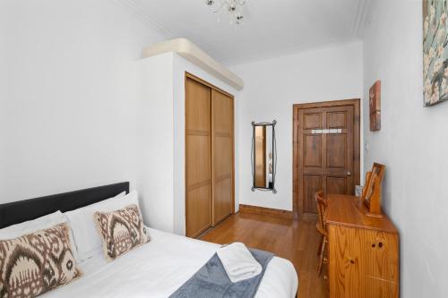 a bedroom with a bed and a wooden table at Beach Walk Apartment in Broughty Ferry