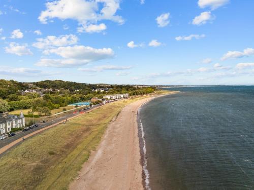 an aerial view of a beach with houses and the ocean at Beach Walk Apartment in Broughty Ferry