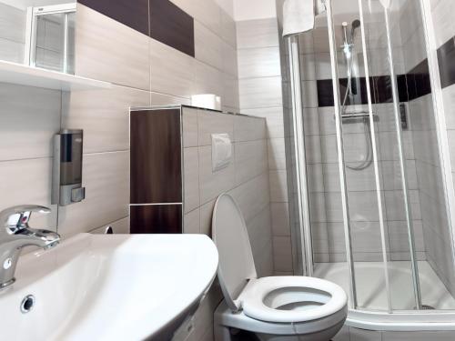 a bathroom with a toilet and a sink and a shower at Hotel Pod Radnicí in Šumperk