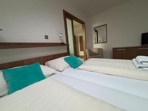 a hotel room with two beds and a mirror at Hotel Pod Radnicí in Šumperk