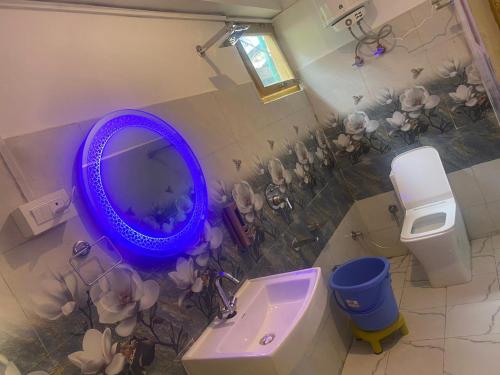 uma casa de banho com um espelho roxo e um lavatório em Om parvati em Kasol