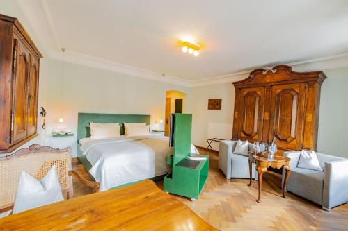 a bedroom with a bed and a couch and a table at Romantik Hotel Meisenheimer Hof in Meisenheim