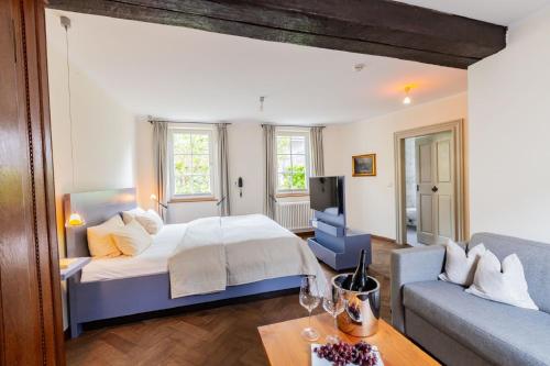 a large bedroom with a bed and a couch at Romantik Hotel Meisenheimer Hof in Meisenheim