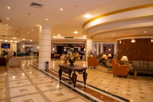 Un vestíbulo con una mesa en el medio de un edificio. en Dexon Roma All Inclusive Hotel, en Hurghada