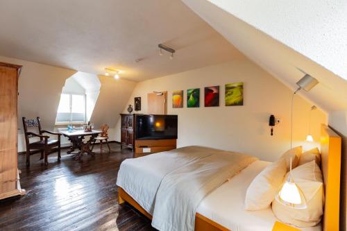 a bedroom with a bed and a dining room with a table at Romantik Hotel Meisenheimer Hof in Meisenheim