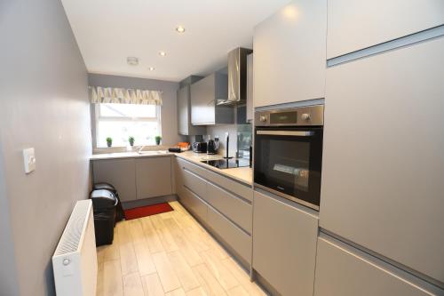 a kitchen with stainless steel appliances and a large window at Harbour View City Centre Apartment in Belfast