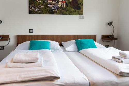 two beds in a room with towels on them at Hotel Pod Radnicí in Šumperk
