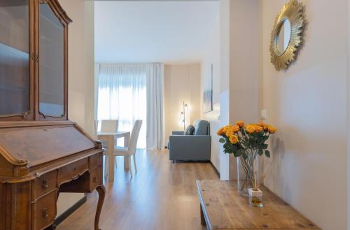 a living room with a piano and a vase of flowers on a table at Milan Retreats in Milan