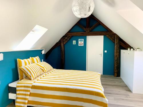 a bedroom with a bed with a yellow and blue wall at Au Clerc de l'Orangerie 2-6 voyageurs in Fécamp