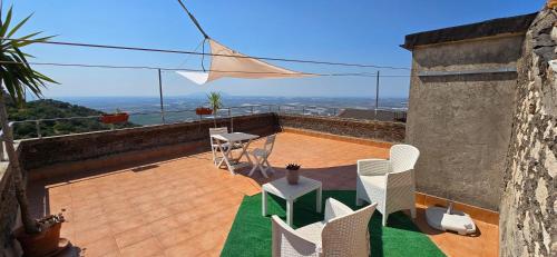 a patio with white chairs and a table on a roof at Alloggio turistico - Sole dall'alba al tramonto in Sezze