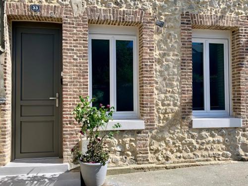 a brick building with a door and two windows at Au Clerc de l'Orangerie 2-6 voyageurs in Fécamp