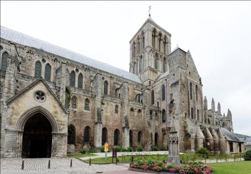 an old stone church with a large building at Au Clerc de l'Orangerie 2-6 voyageurs in Fécamp
