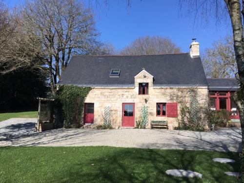 a large stone house with red doors and ivy at Leontine in Saint-Hilaire