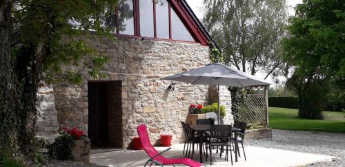 a patio with a table and chairs and an umbrella at Leontine in Saint-Hilaire
