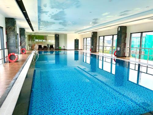 a large swimming pool with blue water in a building at Five Star Studio Apartment Near Marriott Hotel and Keangnam in Hanoi
