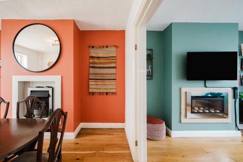 a dining room with orange and blue walls at Heaton House - parkside charm and city comfort in Manchester