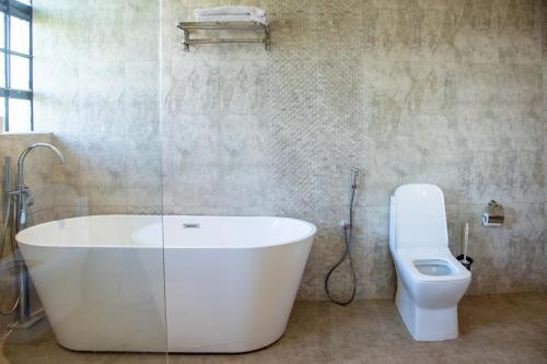 a bathroom with a bath tub and a toilet at Gigiri Lion Villas I in Nairobi