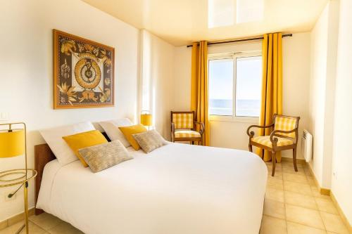 a bedroom with a large white bed with yellow pillows at Vue exceptionnelle début Cap Corse La Pier Noire in San-Martino-di-Lota