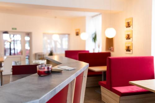a dining room with red chairs and a table at Hotel Pod Radnicí in Šumperk