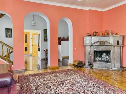 a living room with orange walls and a fireplace at ПростоРа Нагірна in Vitachov